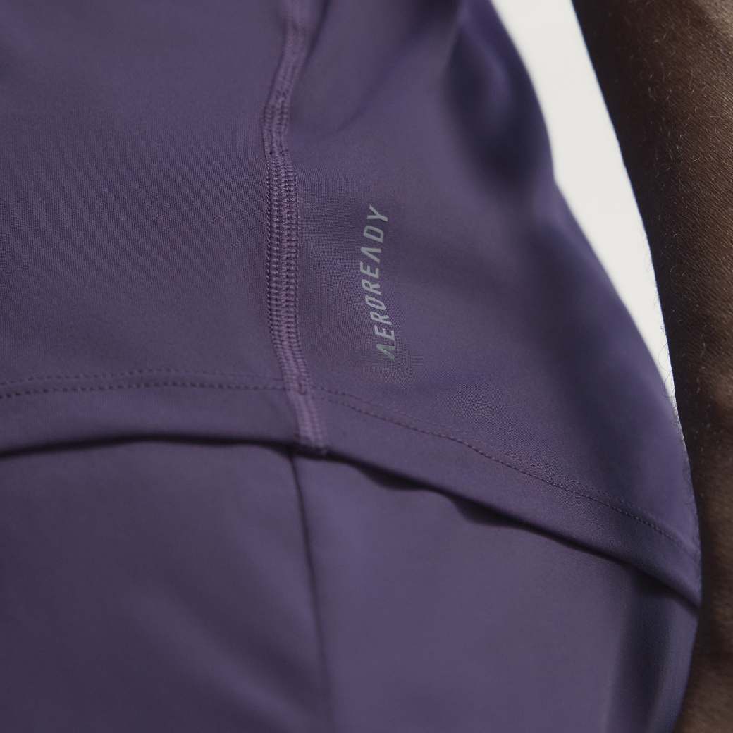Detalhe lateral da camiseta Adidas roxa Aurora Plum mostrando tecnologia AEROREADY